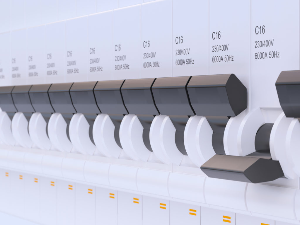 Multiple fuses or switches in a line on a fuse board.