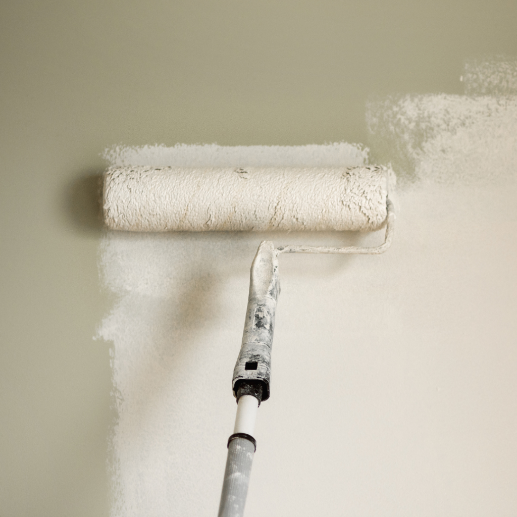 A long roller being used to paint a wall